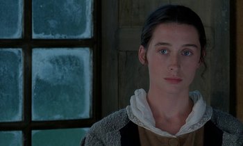 Movie still from “Tous les matins du monde” (1991), directed by Alain Corneau – A young woman with blue eyes is standing in front of a window; Close Up shot, Over the shoulder angle