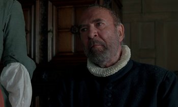 Movie still from “Tous les matins du monde” (1991), directed by Alain Corneau – An older man with a beard wearing a black and white collar; Close Up shot, Over the shoulder angle