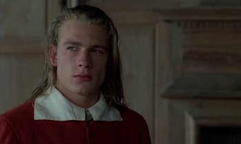 Movie still from “Tous les matins du monde” (1991), directed by Alain Corneau – A man with long blonde hair wearing a red shirt; Close Up shot, Over the shoulder angle