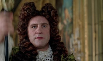 Movie still from “Tous les matins du monde” (1991), directed by Alain Corneau – A man in a long wig and a bow tie; Close Up shot, Over the shoulder angle