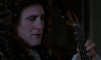 Movie still from “Tous les matins du monde” (1991), directed by Alain Corneau – A man in a wig holding an electric guitar; Close Up shot, Over the shoulder angle