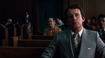 Movie still from “All the President's Men” (1976), directed by Alan J. Pakula – A man in a suit and tie in a court room; Medium shot, Low angle