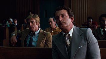Movie still from “All the President's Men” (1976), directed by Alan J. Pakula – Two men in suits are sitting in a courtroom; Medium shot, Low angle