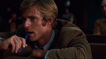 Movie still from “All the President's Men” (1976), directed by Alan J. Pakula – A person holding a pen in his mouth; Close Up shot, Low angle