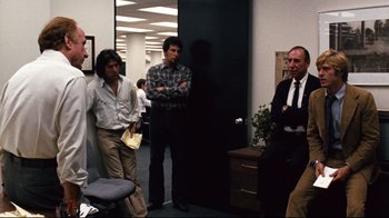 A group of men standing in an office room