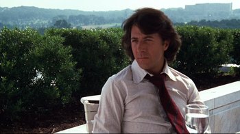 Movie still from “All the President's Men” (1976), directed by Alan J. Pakula – A man sitting on top of a chair wearing a shirt and tie; Close Up shot, Low angle
