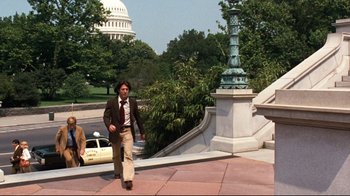 Movie still from “All the President's Men” (1976), directed by Alan J. Pakula – A man walking down the sidewalk in front of the capitol building; Wide shot, Low angle