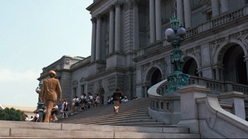 Movie still from “All the President's Men” (1976), directed by Alan J. Pakula – A group of people walking up and down a set of stairs; Extreme Wide shot, Low angle
