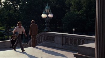 Movie still from “All the President's Men” (1976), directed by Alan J. Pakula – A man standing on a bridge looking at a lamp post; Extreme Wide shot, High angle