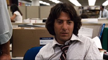 Movie still from “All the President's Men” (1976), directed by Alan J. Pakula – A man sitting in an office chair wearing a tie; Close Up shot, Low angle