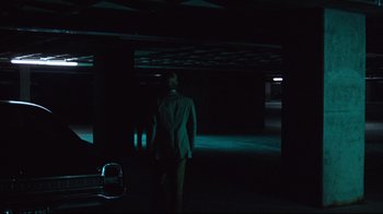 Movie still from “All the President's Men” (1976), directed by Alan J. Pakula – A man in a suit standing in a dark room; Wide shot, Low angle