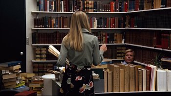 Movie still from “All the President's Men” (1976), directed by Alan J. Pakula – A woman standing in front of a book shelf; Medium shot, Over the shoulder angle
