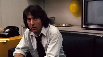 Movie still from “All the President's Men” (1976), directed by Alan J. Pakula – A man sitting on top of a couch wearing a tie; Close Up shot, Over the shoulder angle