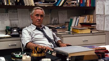 Movie still from “All the President's Men” (1976), directed by Alan J. Pakula – An older man sitting at a desk in an office; Medium shot, High angle