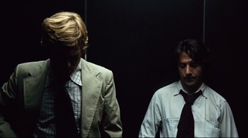 Movie still from “All the President's Men” (1976), directed by Alan J. Pakula – Two men standing next to each other in front of a black wall; Medium shot, Low angle