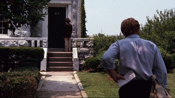 Movie still from “All the President's Men” (1976), directed by Alan J. Pakula – A man standing in front of a door way; Wide shot, Over the shoulder angle