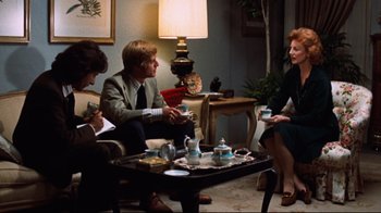 Movie still from “All the President's Men” (1976), directed by Alan J. Pakula – A group of people sitting around a living room table; Medium shot, Over the shoulder angle
