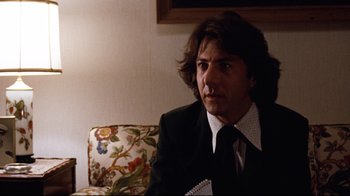Movie still from “All the President's Men” (1976), directed by Alan J. Pakula – A man in a suit and tie sitting on a couch; Close Up shot, Low angle