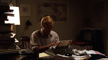 Movie still from “All the President's Men” (1976), directed by Alan J. Pakula – A man sitting at a table using a laptop computer; Medium shot, High angle
