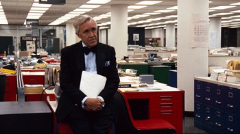 Movie still from “All the President's Men” (1976), directed by Alan J. Pakula – An older man in a suit sitting at a desk in an office; Medium shot, Over the shoulder angle