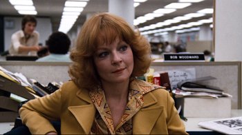 Movie still from “All the President's Men” (1976), directed by Alan J. Pakula – An older woman with red hair wearing a yellow jacket; Close Up shot, Low angle