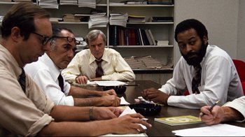 A group of men sitting at a table in front of papers