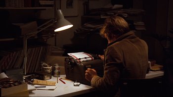 Movie still from “All the President's Men” (1976), directed by Alan J. Pakula – A person sitting at a table with a typewriter; Medium shot, High angle