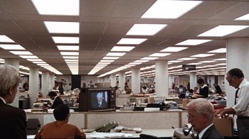 Movie still from “All the President's Men” (1976), directed by Alan J. Pakula – People in an office with a tv on the wall; Extreme Wide shot, High angle