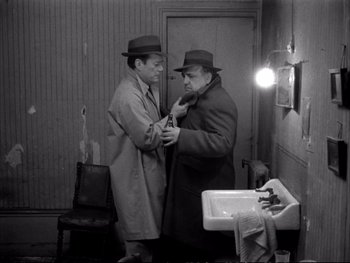 Movie still from “Alphaville” (1965), directed by Jean-Luc Godard – A couple of men standing next to each other in front of a sink; Medium shot, High angle