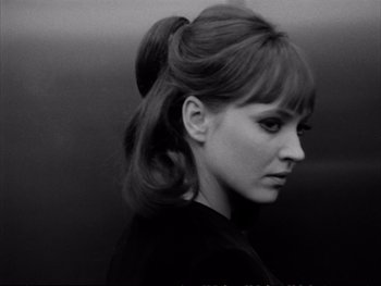 Movie still from “Alphaville” (1965), directed by Jean-Luc Godard – A black and white photo of a woman with a ponytail; Close Up shot, Low angle