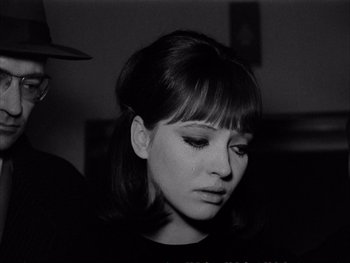 Movie still from “Alphaville” (1965), directed by Jean-Luc Godard – A black and white photo of a woman looking down at her face; Close Up shot, Over the shoulder angle