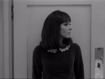 Movie still from “Alphaville” (1965), directed by Jean-Luc Godard – A woman with long black hair wearing a black sweater; Close Up shot, High angle