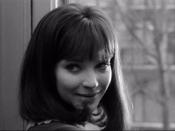 Movie still from “Alphaville” (1965), directed by Jean-Luc Godard – A black and white photo of a woman smiling; Close Up shot, High angle