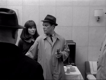 Movie still from “Alphaville” (1965), directed by Jean-Luc Godard – A black and white photo of a man and a woman; Medium shot, Over the shoulder angle
