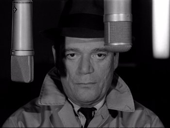 Movie still from “Alphaville” (1965), directed by Jean-Luc Godard – A black and white photo of a man in a hat; Close Up shot, Low angle