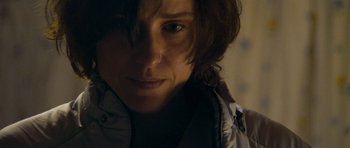 Movie still from “Alps” (2011), directed by Yorgos Lanthimos – A person's face in the dark; Close Up shot, Over the shoulder angle