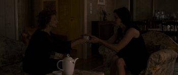 Movie still from “Alps” (2011), directed by Yorgos Lanthimos – Two women sitting in front of a tea pot and a tea cup; Medium shot, High angle