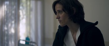 Movie still from “Alps” (2011), directed by Yorgos Lanthimos – A person sitting at a table; Close Up shot, Over the shoulder angle