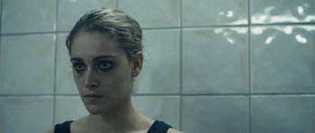 Movie still from “Alps” (2011), directed by Yorgos Lanthimos – A person wearing a black shirt; Close Up shot, Over the shoulder angle