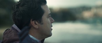 Movie still from “Alps” (2011), directed by Yorgos Lanthimos – A person's face with a river in the background; Close Up shot, Low angle