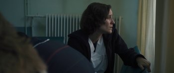 Movie still from “Alps” (2011), directed by Yorgos Lanthimos – A woman sitting in front of a radiator looking off into the distance; Close Up shot, Over the shoulder angle