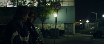 Movie still from “Alps” (2011), directed by Yorgos Lanthimos – A woman standing in front of a street sign; Medium shot, Over the shoulder angle