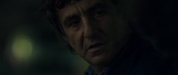 Movie still from “Alps” (2011), directed by Yorgos Lanthimos – A man's face in the dark; Close Up shot, Over the shoulder angle