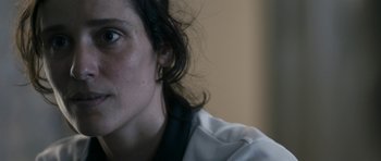 Movie still from “Alps” (2011), directed by Yorgos Lanthimos – A woman's face with a white shirt; Close Up shot, Over the shoulder angle