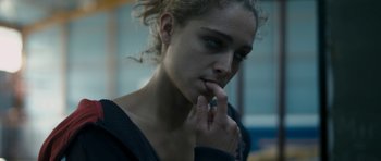 Movie still from “Alps” (2011), directed by Yorgos Lanthimos – A young woman is looking down at her face; Close Up shot, Over the shoulder angle