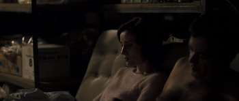 Movie still from “Alps” (2011), directed by Yorgos Lanthimos – A woman sitting in a chair in a dark room; Medium shot, High angle
