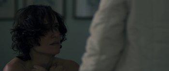 Movie still from “Alps” (2011), directed by Yorgos Lanthimos – A woman looking into a mirror in a room; Close Up shot, Over the shoulder angle