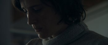 Movie still from “Alps” (2011), directed by Yorgos Lanthimos – A woman's face in the dark; Extreme Close Up shot, Over the shoulder angle