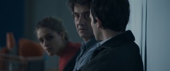 Movie still from “Alps” (2011), directed by Yorgos Lanthimos – A group of people that are sitting in a room together; Close Up shot, Over the shoulder angle