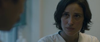 Movie still from “Alps” (2011), directed by Yorgos Lanthimos – A person with short hair; Close Up shot, Over the shoulder angle